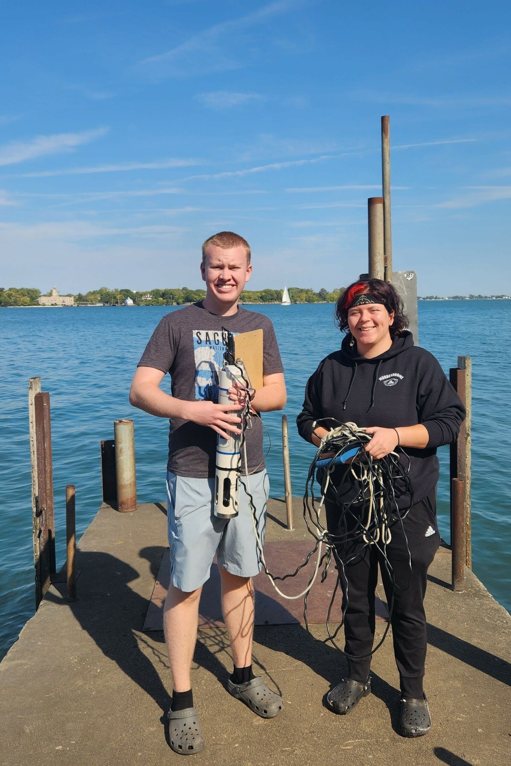 Two students on a dock holding the Hydrolab.